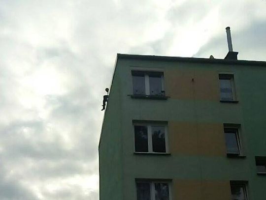 Mężczyzna siedzi na skraju dachu czteropiętrowego bloku w Blachowni. Może chcieć skoczyć
