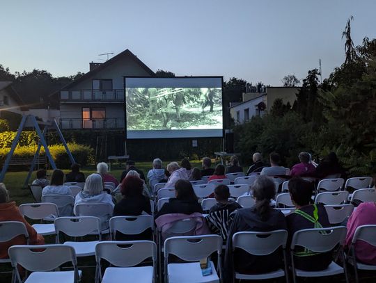 Mieszkańcy osiedla Kuźniczka oglądają film "Wszystko o moim starym". Kino pod chmurką na osiedlowym placu zabaw