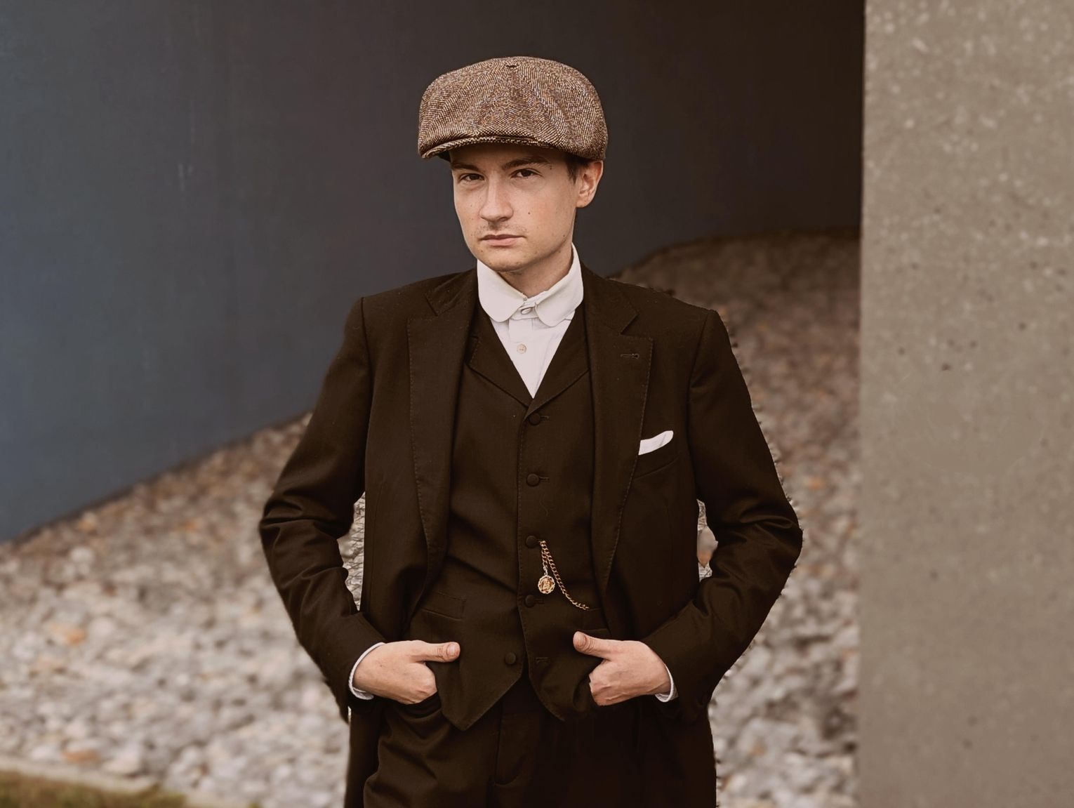 Chłopak w kaszkiecie na ulicach naszego miasta. Garnitur i zegarek na łańcuszku to jego codzienność, nie przebranie