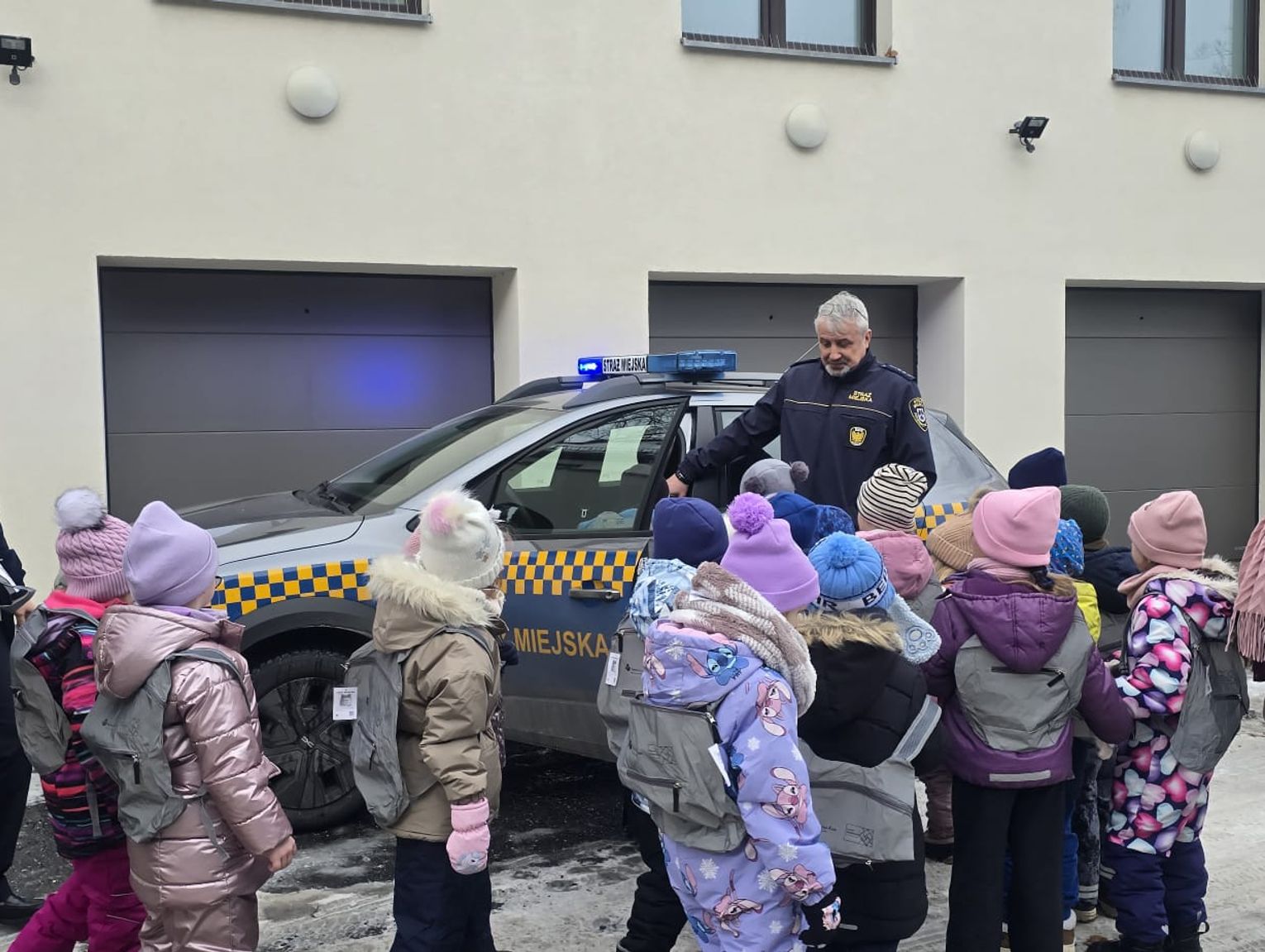 Lekcja bezpieczeństwa ze strażnikami miejskimi. Przedszkolaki dostały odblaskowe szelki i plecaki