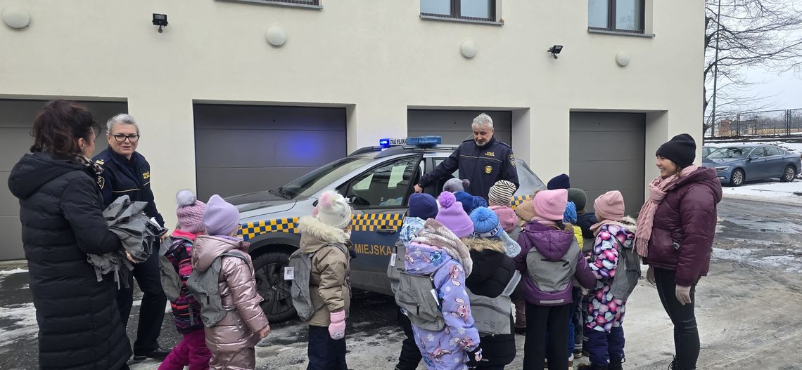 Lekcja bezpieczeństwa ze strażnikami miejskimi. Przedszkolaki dostały odblaskowe szelki i plecaki