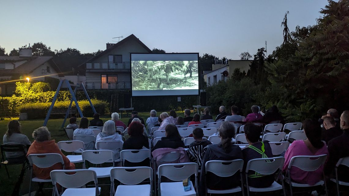 Mieszkańcy osiedla Kuźniczka oglądają film "Wszystko o moim starym". Kino pod chmurką na osiedlowym placu zabaw